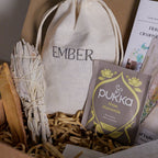 Box containing Ember tea bag, Pukka tea packaging, and other items.