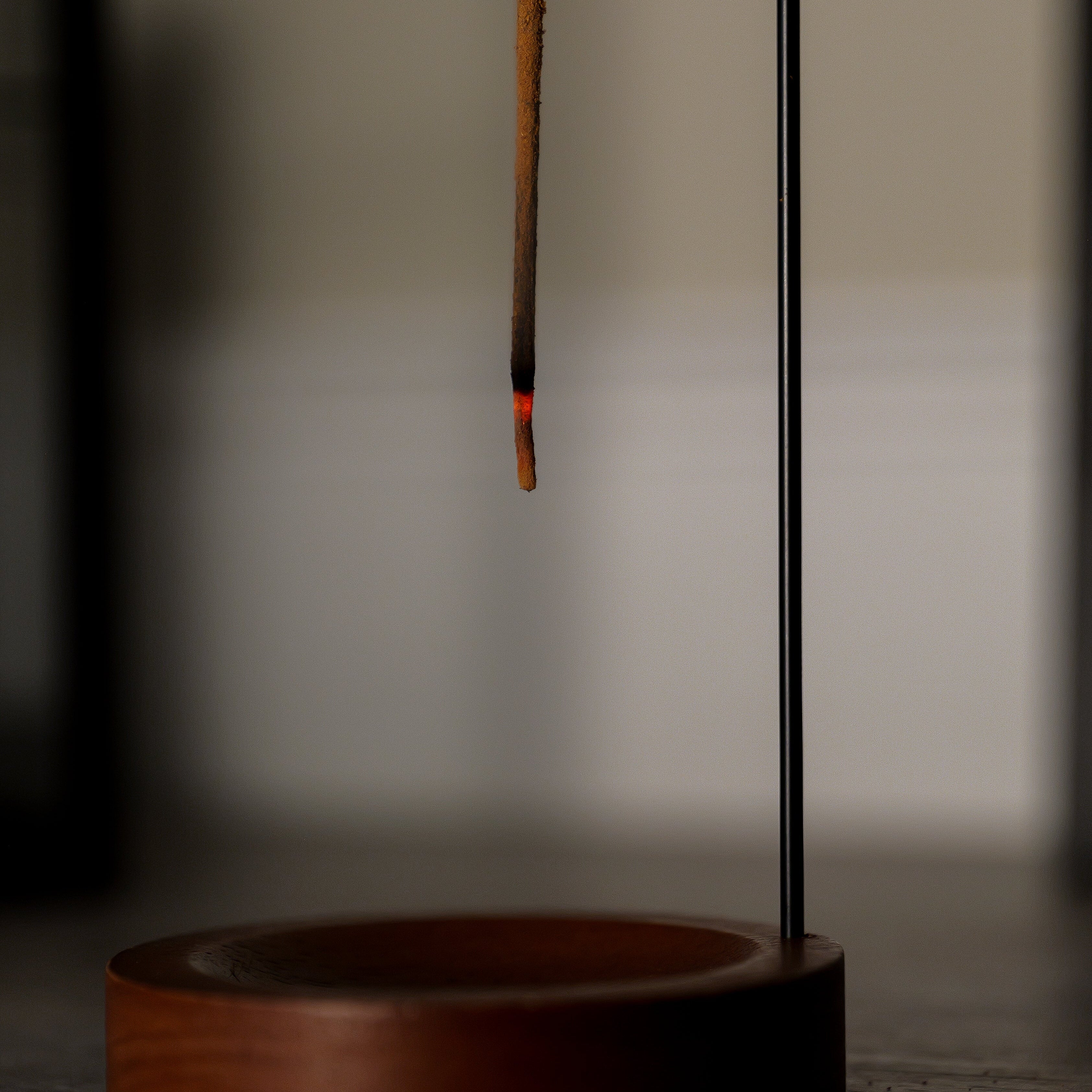 Incense stick with a wooden base on a blurred background
