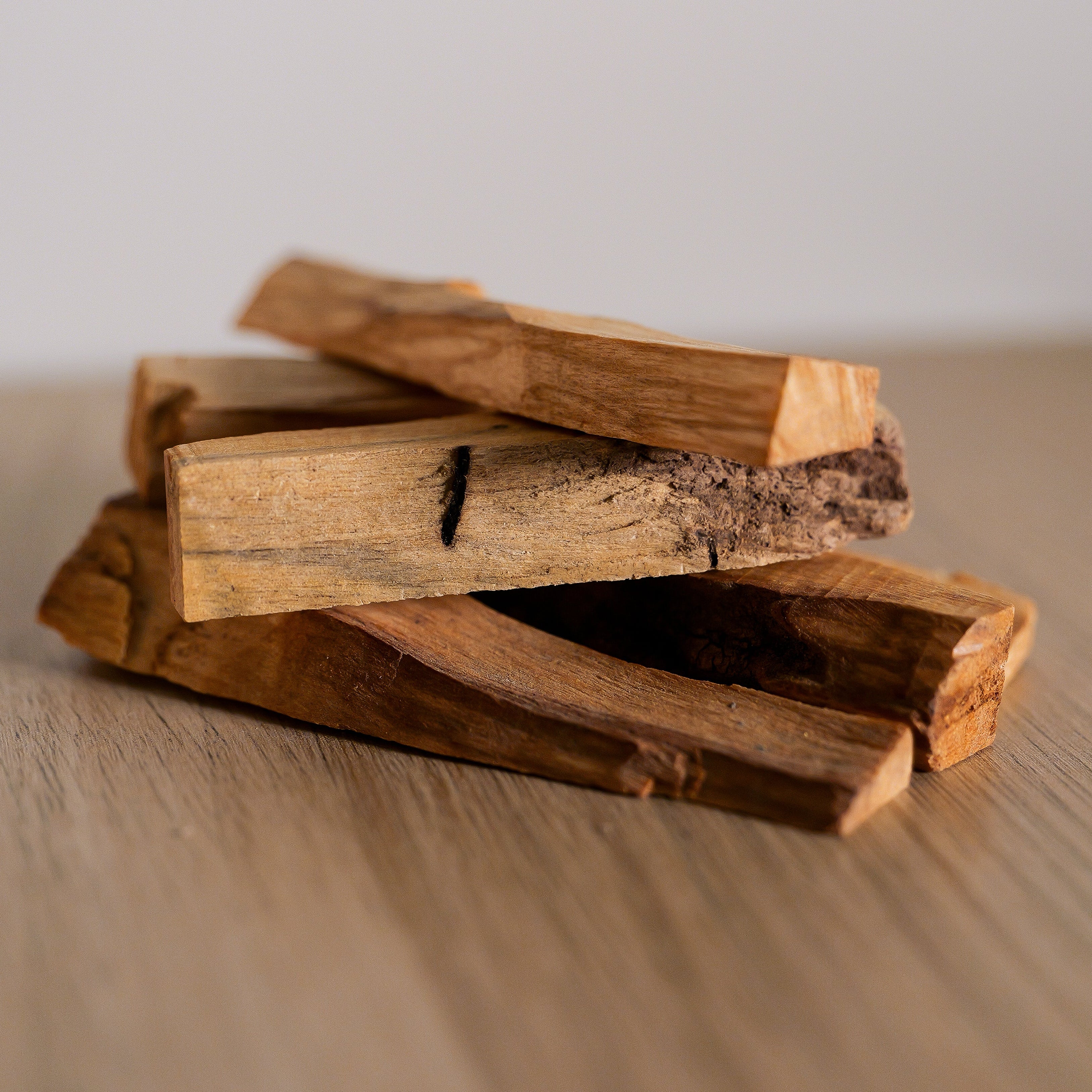 Stack of wooden sticks on a wooden surface with a neutral background