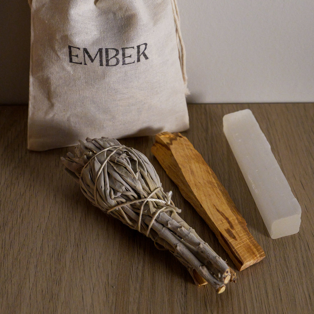 Ember product set with a drawstring bag, wooden sticks, and a white block on a wooden surface.
